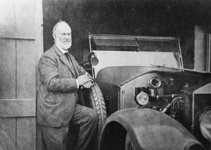 Sir Henry Royce besde car with open bonnet