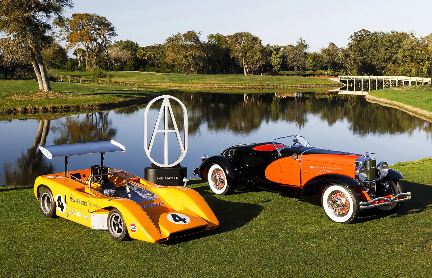 The 2026 Amelia Concours Best of Show winners - a 1969 McLaren M8B and the 1931 Duesenberg Model J 'Tapertail' Speedster by Weymann - with The Amelia trophy on the fairways of The Golf Club of Amelia Island. Photo by Mark Tierney.