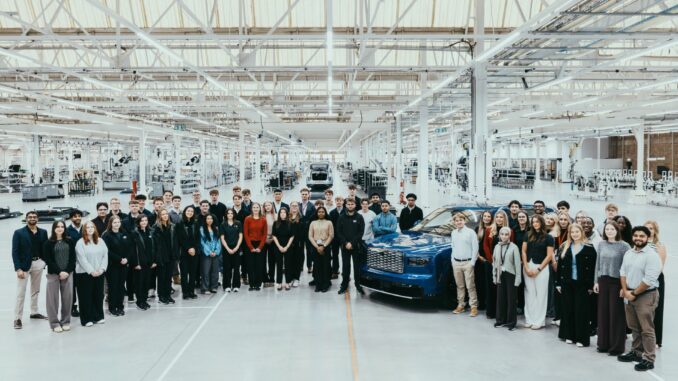 Bentley 2027 early careers cohort gathered around a blue Bentley inside the Crewe factory
