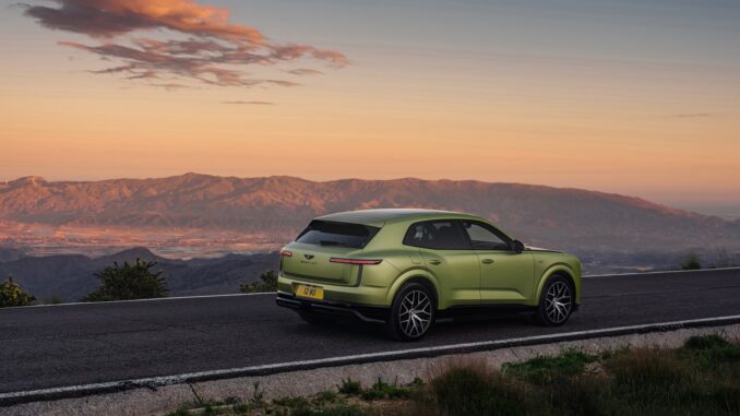 Rear three-quarter view of the all-new Bentley Torcal in light green on a mountain road at sunset