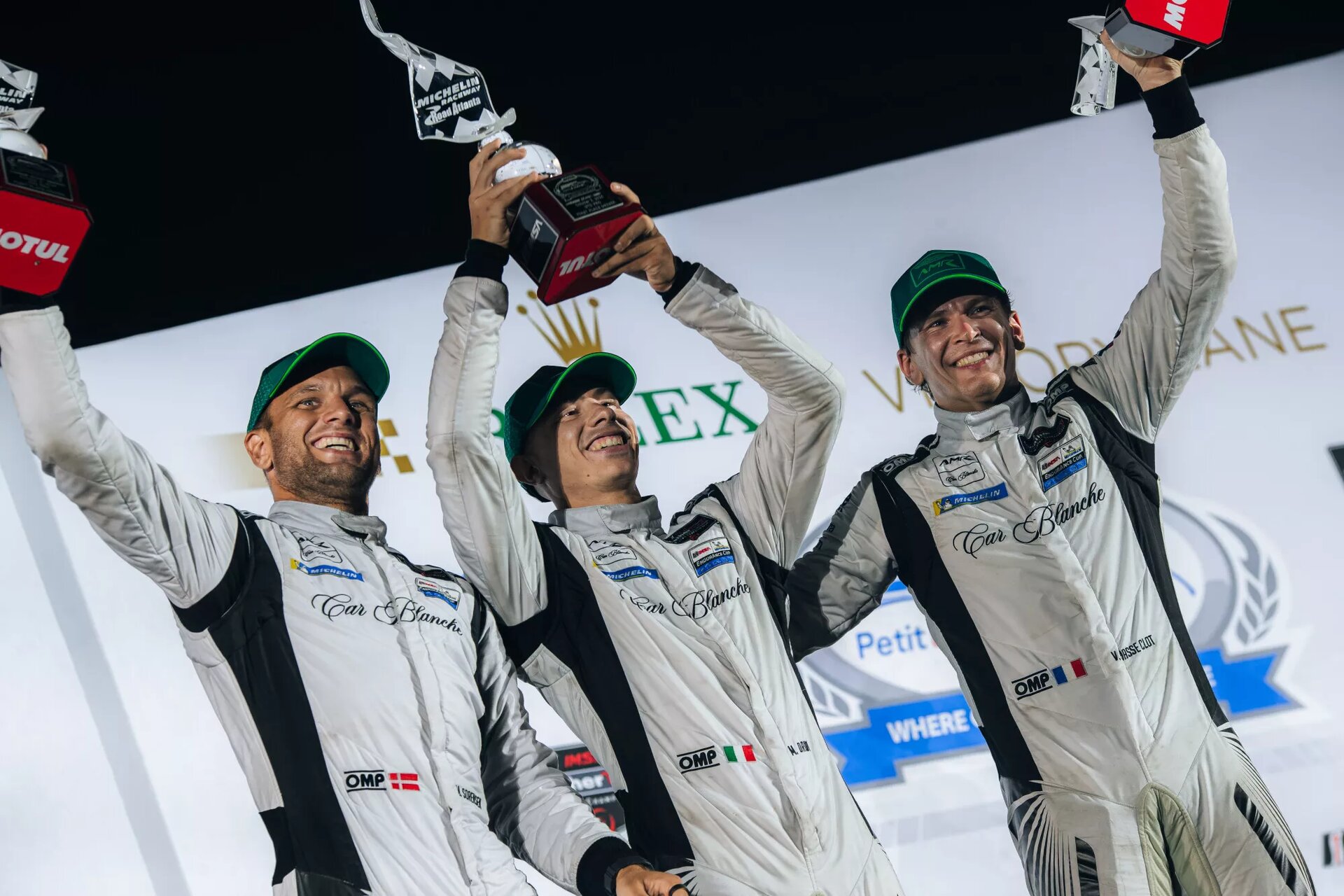 Car Blanche drivers Valentin Hasse Clot, Mattia Drudi and Marco Sorensen celebrate their maiden GTD Pro victory on the Petit Le Mans podium