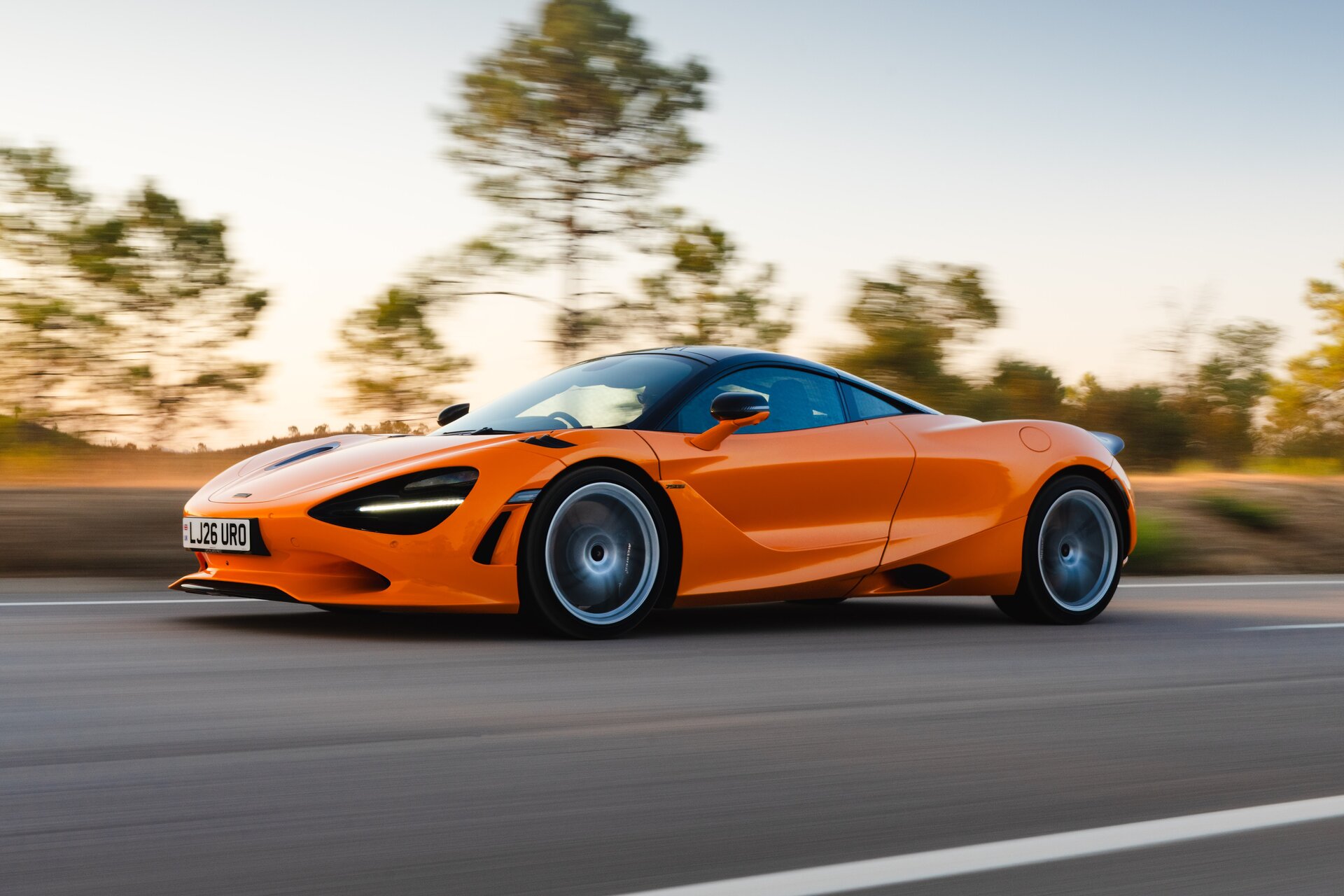 McLaren 750S coupe driving on a country road at speed