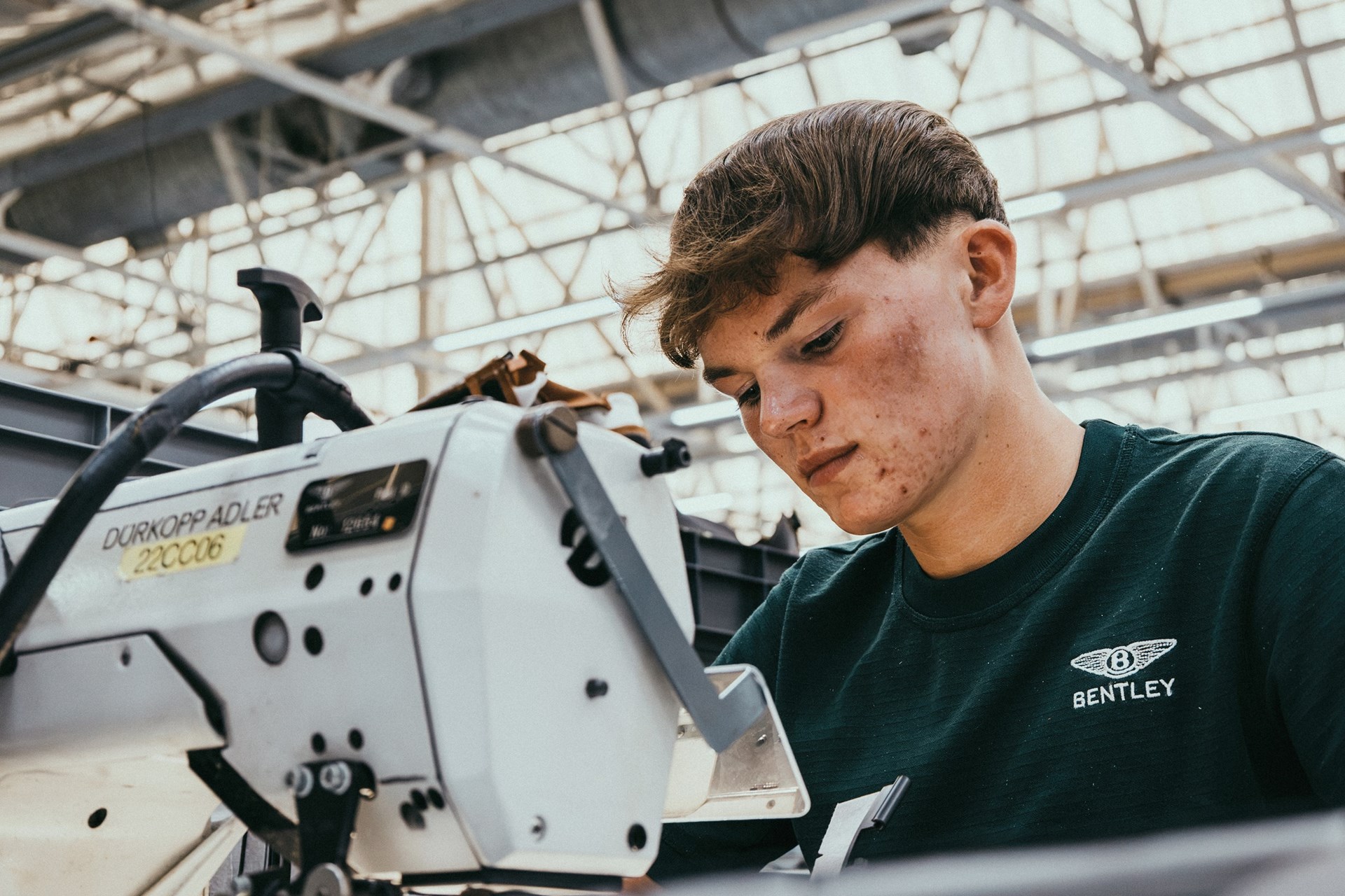 A Bentley apprentice working at a sewing machine in the Crewe trim shop