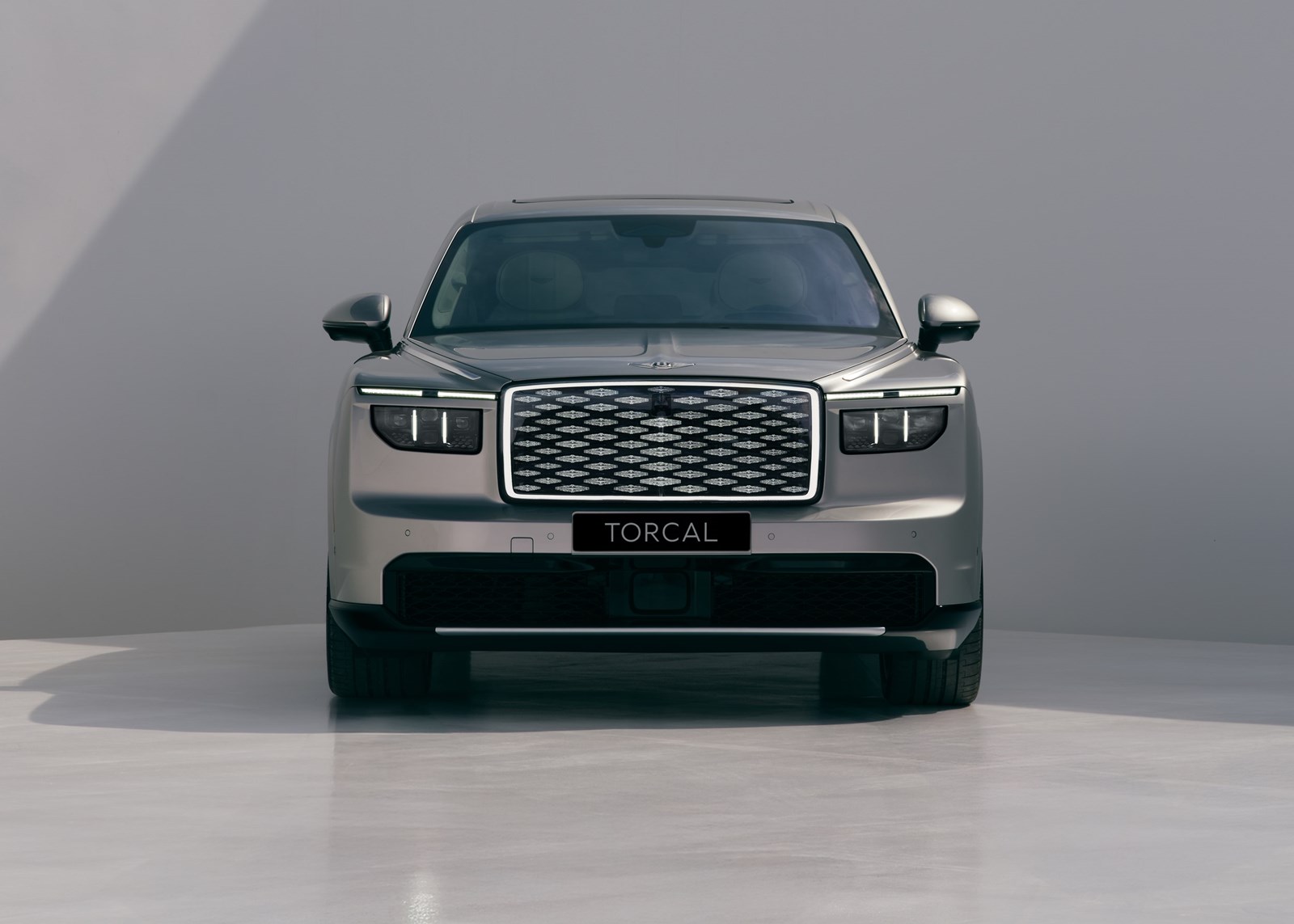 Head-on view of the Bentley Torcal showing its illuminated diamond-pattern grille and slim LED headlights