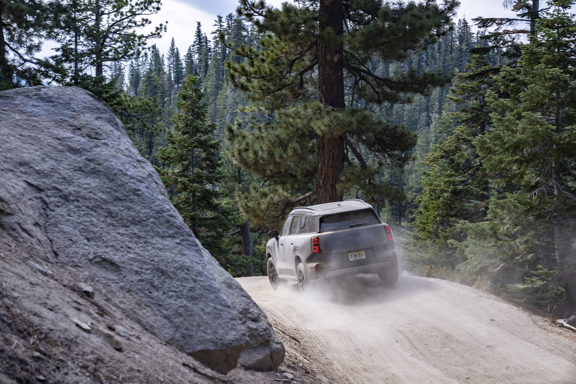 MINI Countryman Untamed Edition kicking up dust on a dirt trail, rear view
