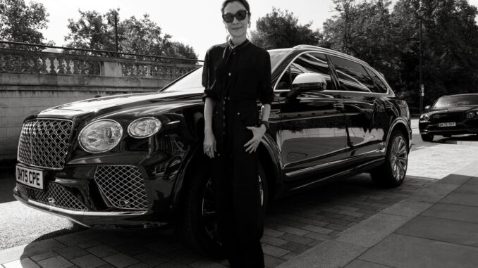 Michelle Yeoh standing beside a Bentley Bentayga, black and white portrait