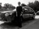 Michelle Yeoh standing beside a Bentley Bentayga, black and white portrait