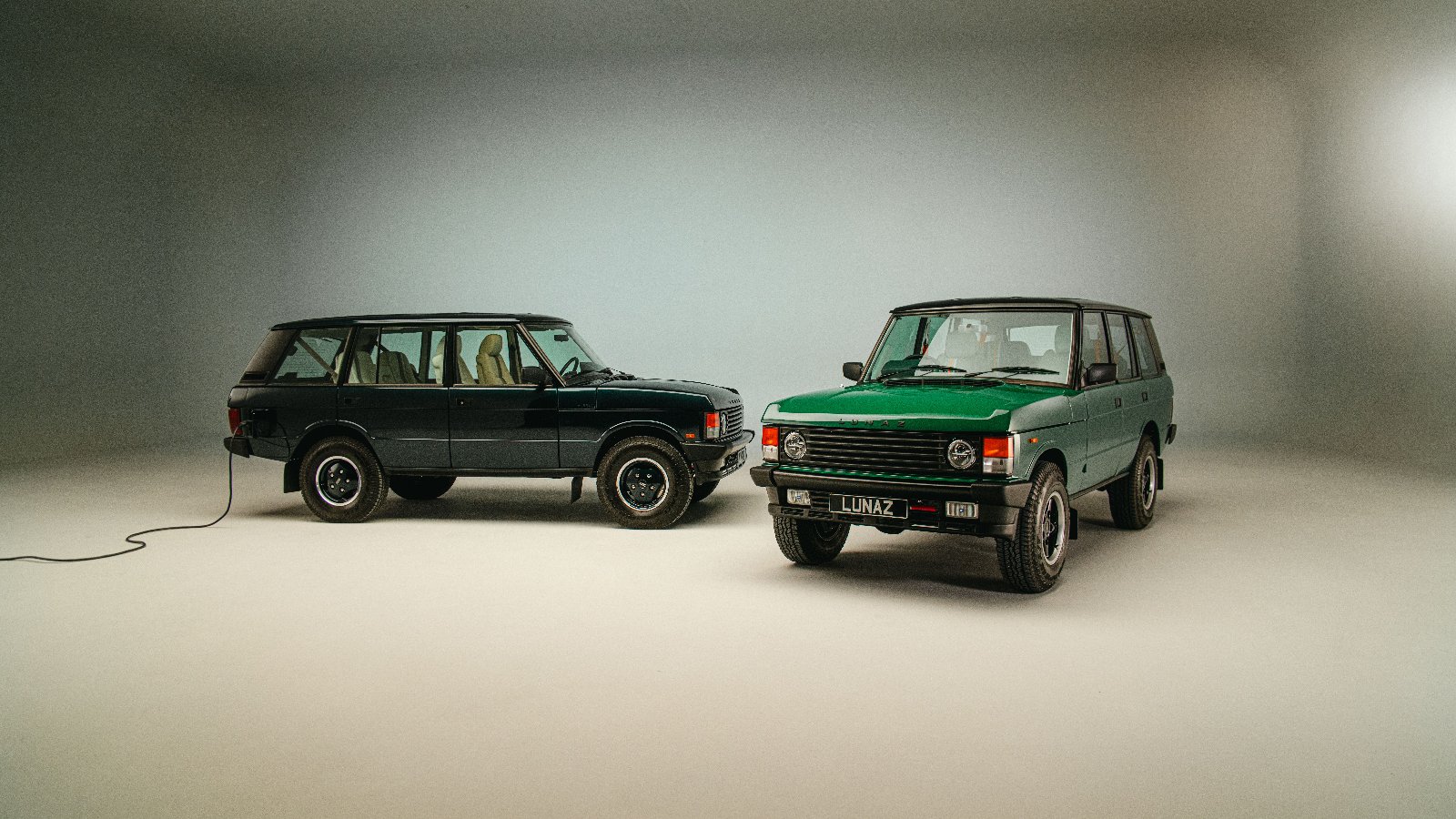 Two Range Rover Classic by Lunaz restomods in a studio, one plugged in to charge
