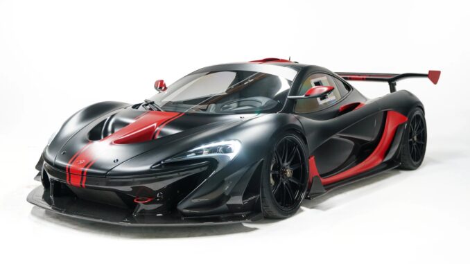 The 2015 McLaren P1 GTR by Lanzante in matte black with red and carbon fiber accents, front three-quarter studio shot