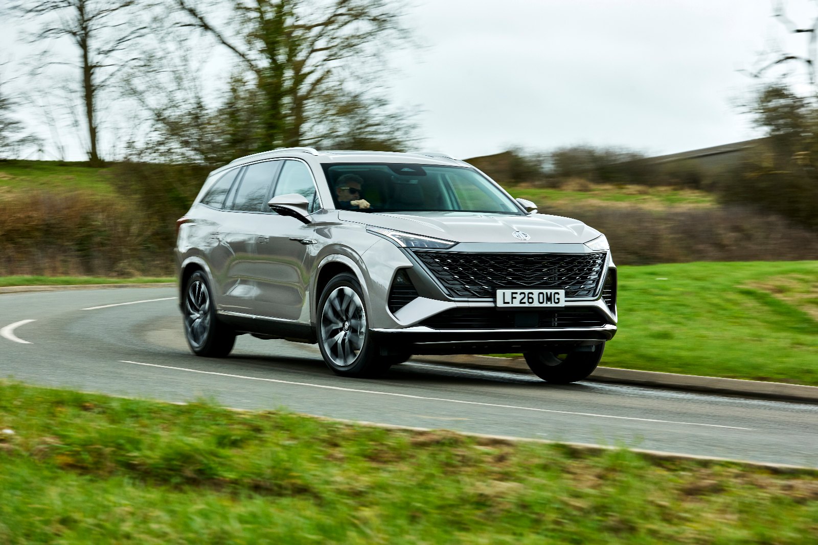 Silver MG MGS9 PHEV driving along a country road, front three-quarter view