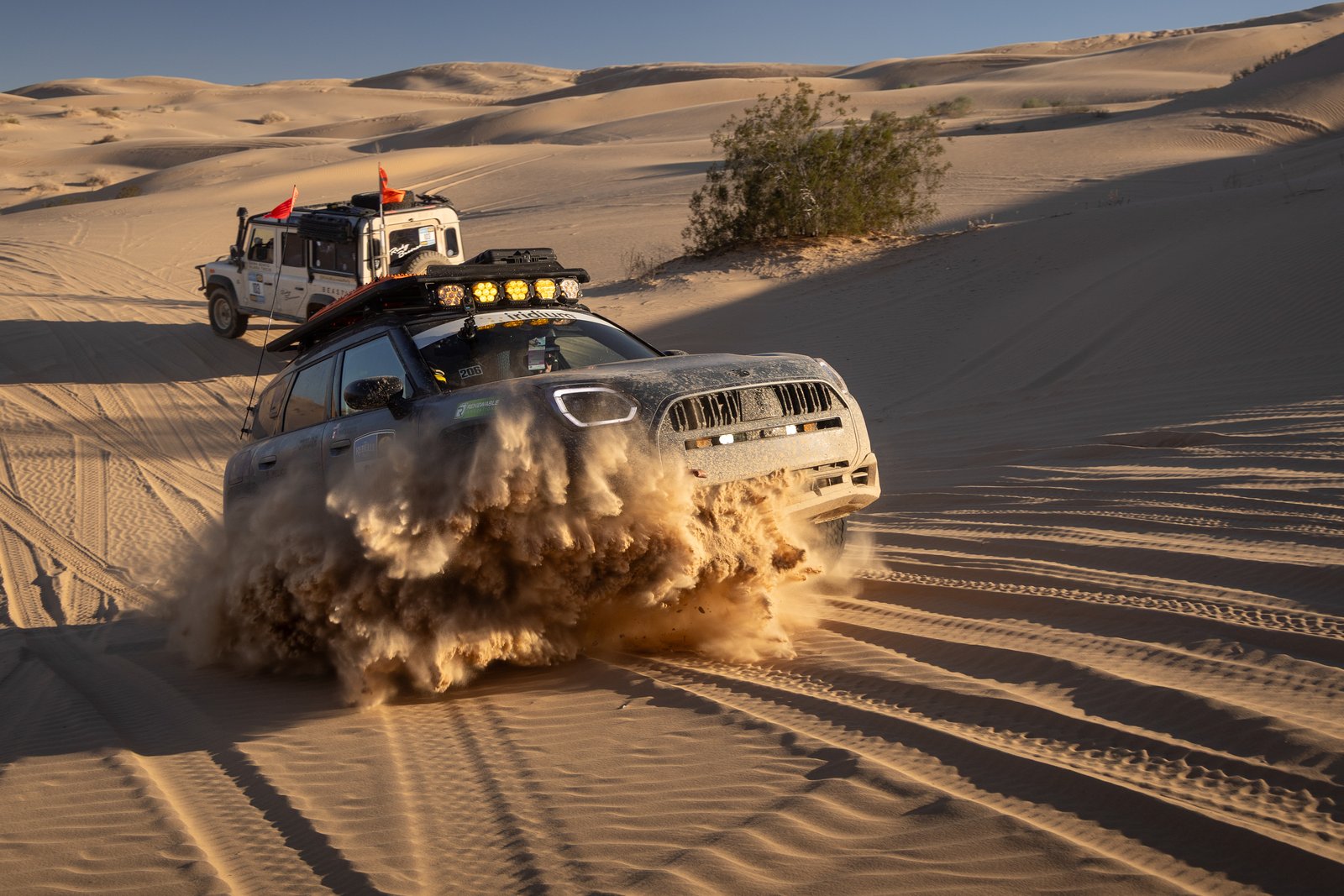 The 2027 MINI Countryman Untamed Edition powers through soft sand dunes, trailing another 4x4