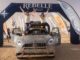 Felicia Killman and Erika Ferrer stand on their dust-covered MINI Countryman celebrating under the Rebelle Rally finish arch